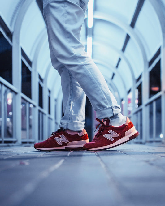 person wearing pair of red New Balance low-top sneakers