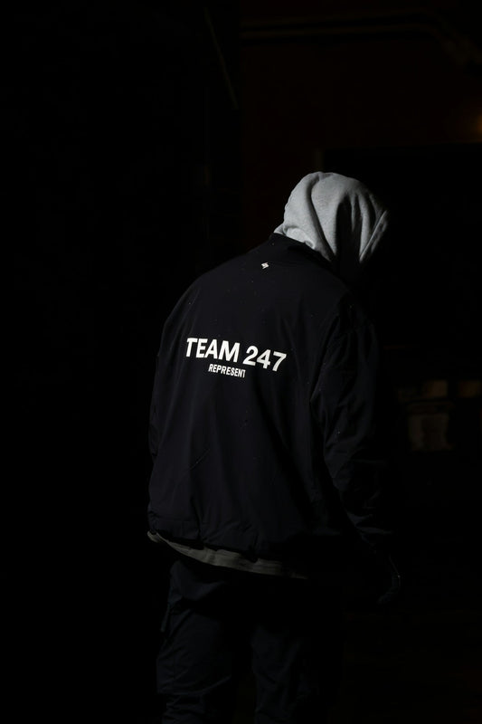 A man in a hoodie standing in the dark